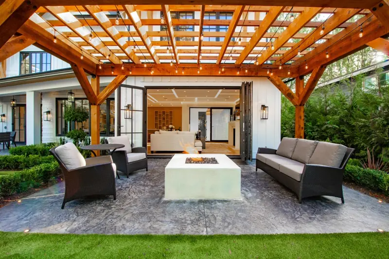 a patio with a fire pit and chairs