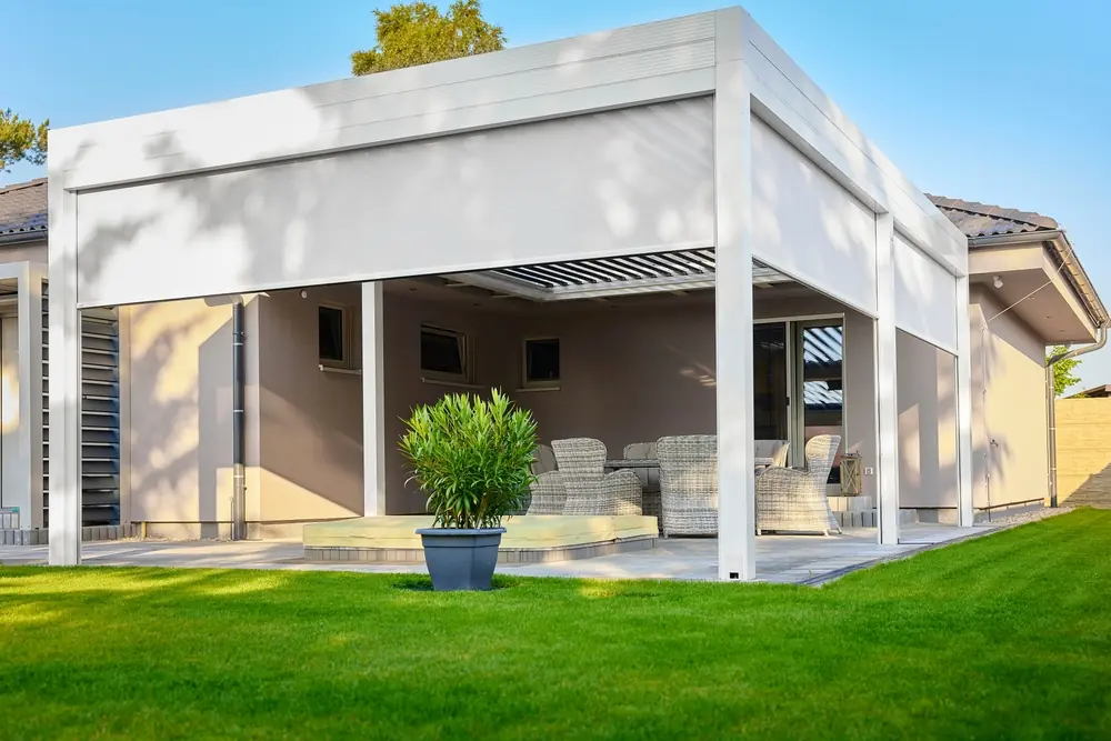 a white building with a patio and a potted plant