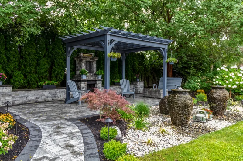 a patio with a pergola and chairs