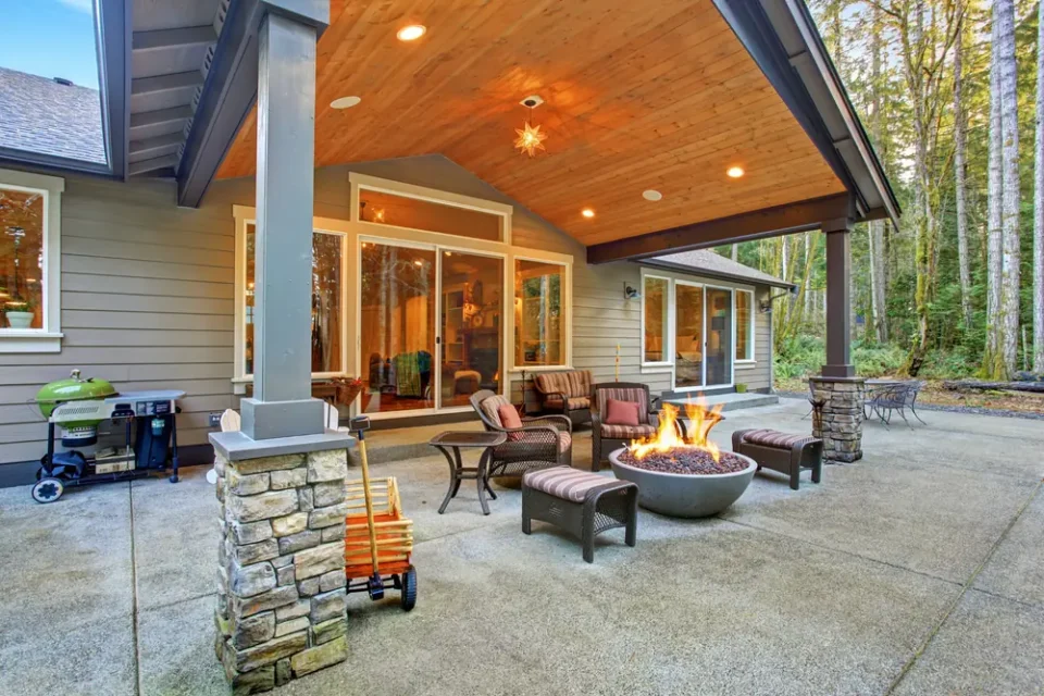 a patio with a fire pit and chairs